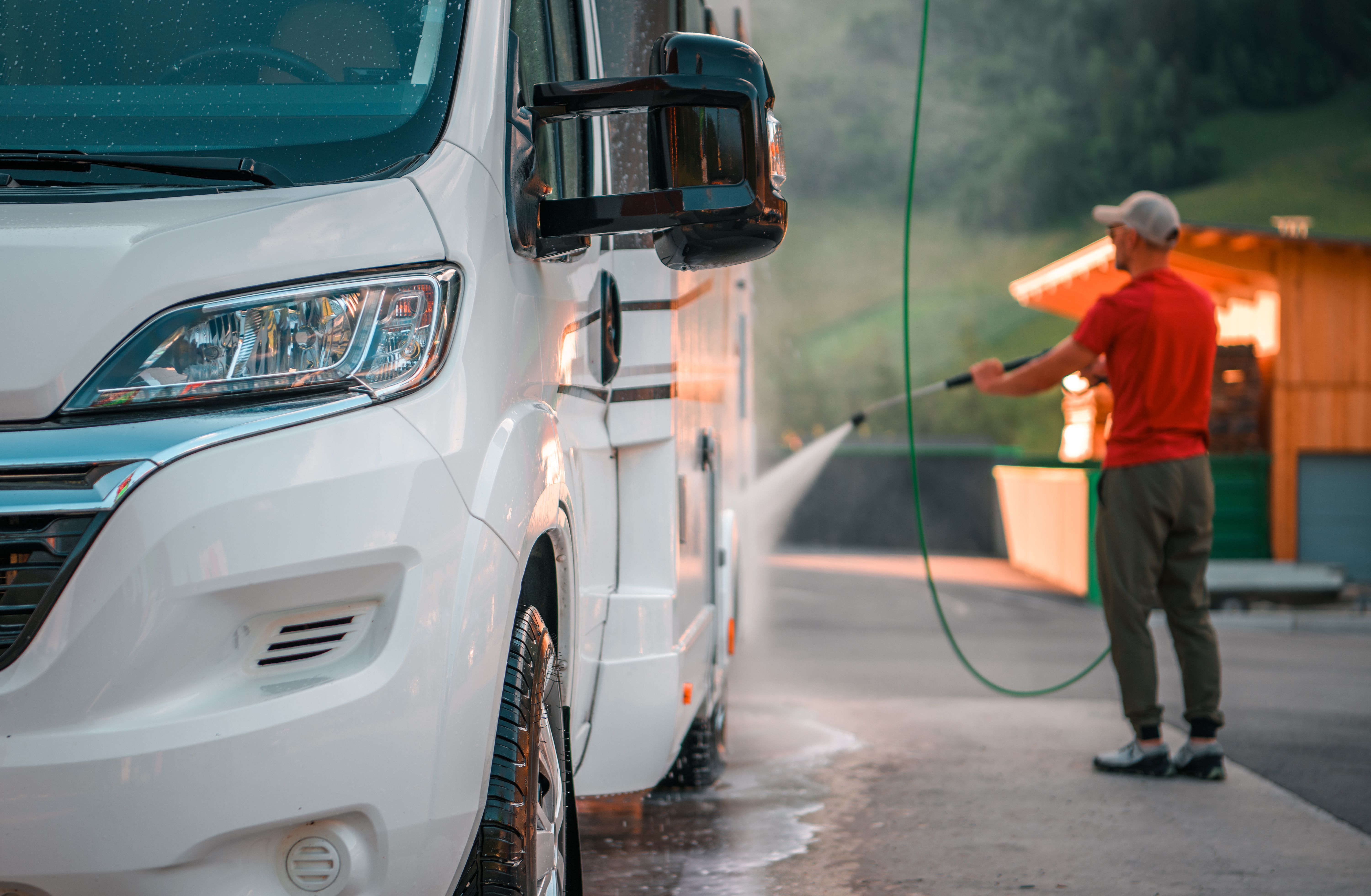 a man washing the exterior of his motorhome as part of his RV maintenance checklist